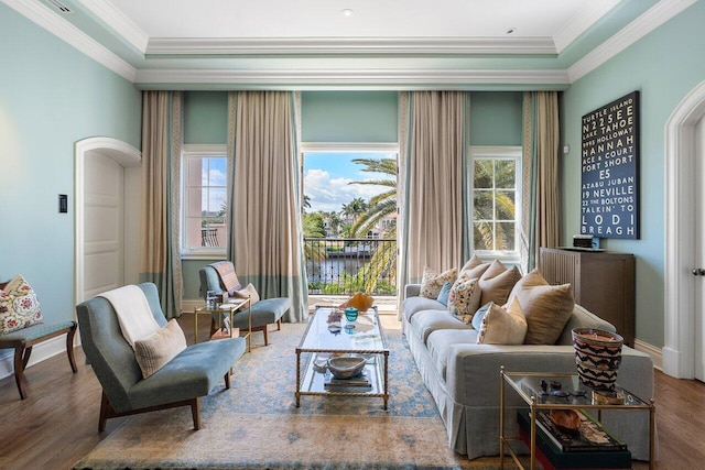 living room with hardwood / wood-style floors, crown molding, and a healthy amount of sunlight