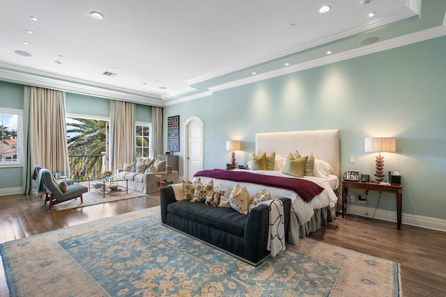 bedroom featuring a tray ceiling, ornamental molding, and dark wood-type flooring