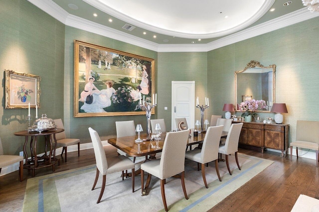 dining space featuring crown molding, wood-type flooring, and a raised ceiling