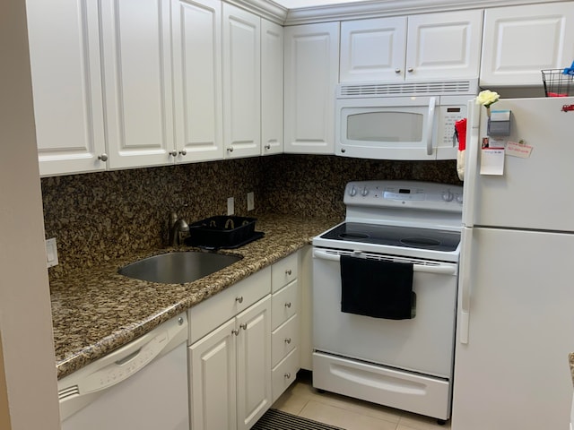 kitchen featuring white appliances, white cabinetry, backsplash, and light tile floors