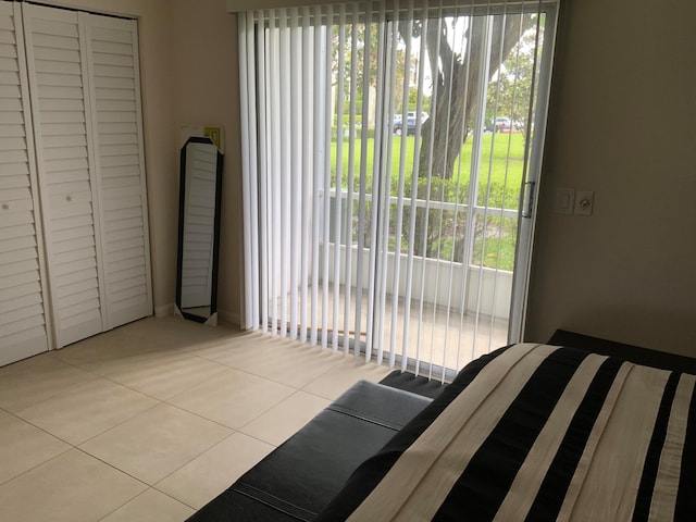 tiled bedroom with a closet and multiple windows