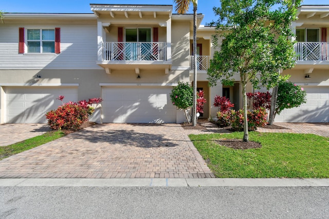 townhome / multi-family property featuring a balcony and a garage