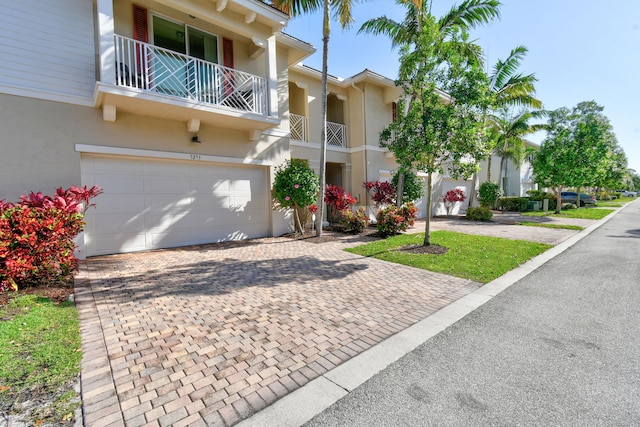 view of front of property featuring a garage and a balcony