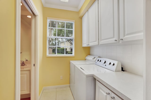 laundry area with washer and dryer, a healthy amount of sunlight, light tile flooring, and cabinets