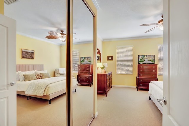 carpeted bedroom featuring ceiling fan and crown molding