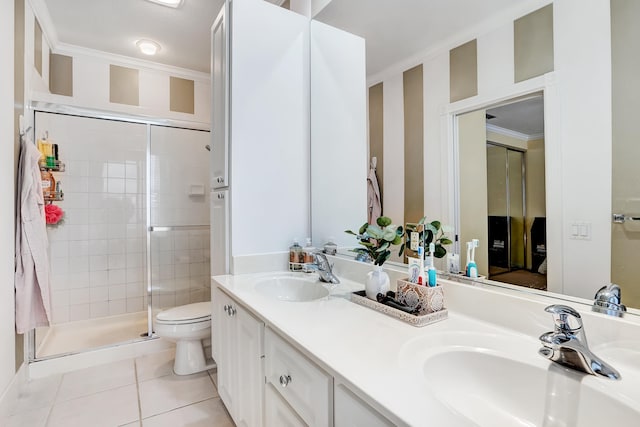 bathroom featuring toilet, vanity with extensive cabinet space, a shower with door, dual sinks, and tile flooring