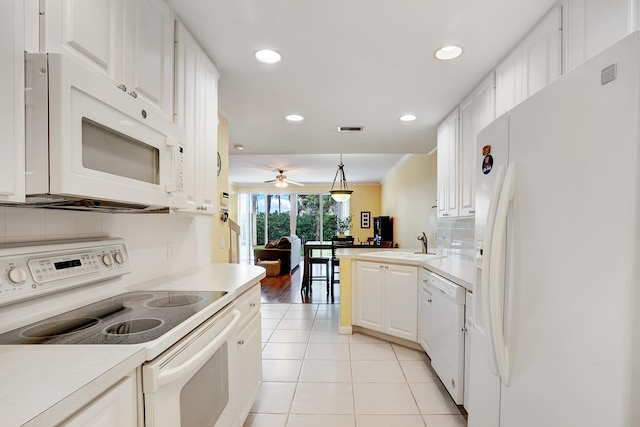 kitchen with hanging light fixtures, backsplash, ceiling fan, white appliances, and white cabinets