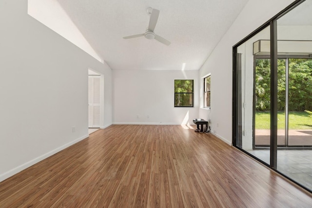 empty room with vaulted ceiling, ceiling fan, and hardwood / wood-style flooring