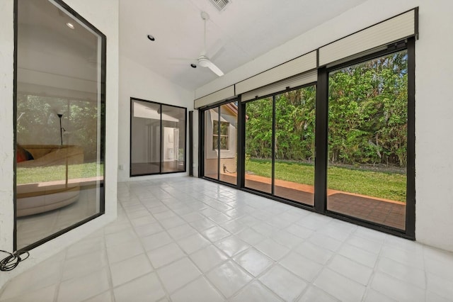 interior space with a healthy amount of sunlight, lofted ceiling, ceiling fan, and light tile flooring