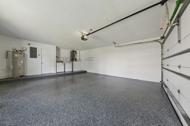 garage with water heater, washing machine and dryer, and a garage door opener