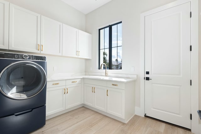 washroom featuring sink, cabinets, washer / clothes dryer, and light hardwood / wood-style floors