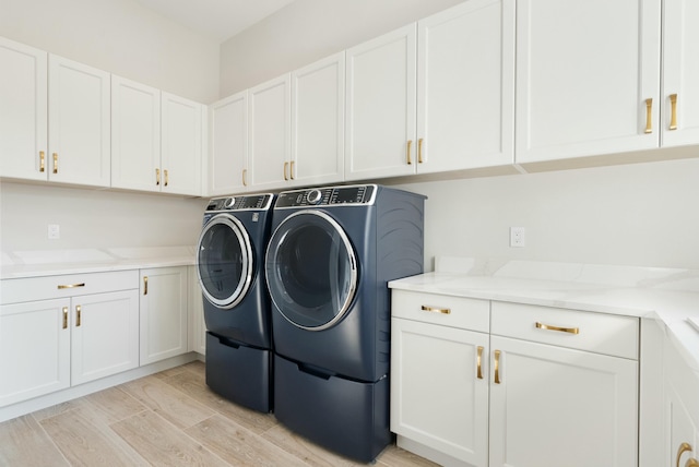 laundry area featuring washer and dryer and cabinets