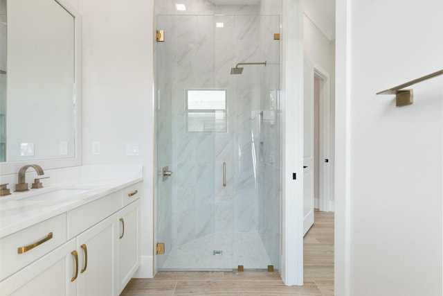 bathroom featuring wood-type flooring, vanity, and walk in shower