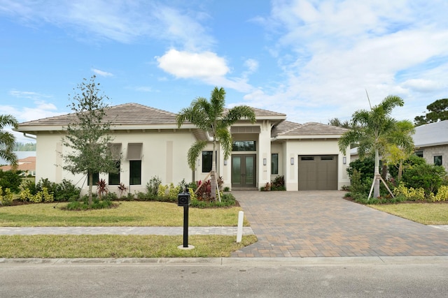 view of front of home featuring french doors, a front yard, and a garage