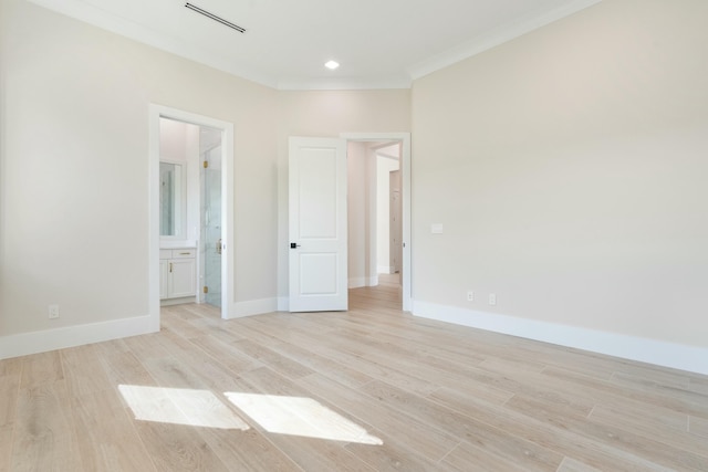 empty room featuring light hardwood / wood-style floors and crown molding