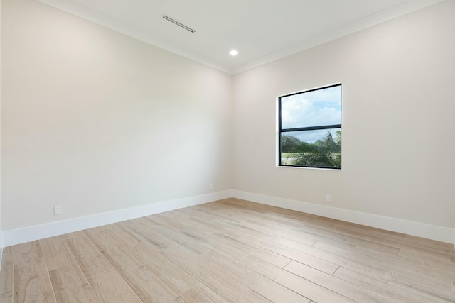 empty room with light wood-type flooring and crown molding