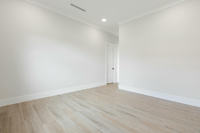 empty room featuring light hardwood / wood-style floors and crown molding