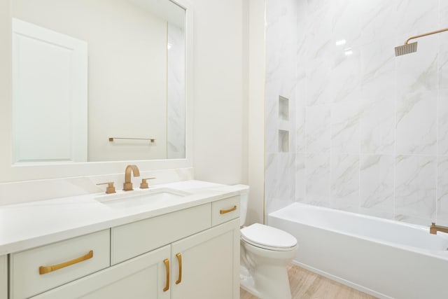 full bathroom featuring toilet, vanity, hardwood / wood-style floors, and tiled shower / bath