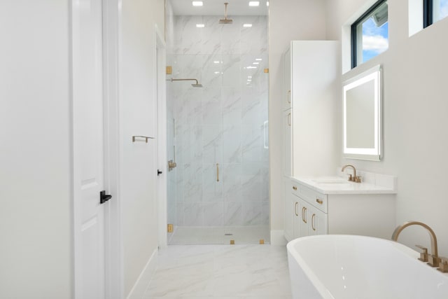 bathroom with vanity and shower with separate bathtub