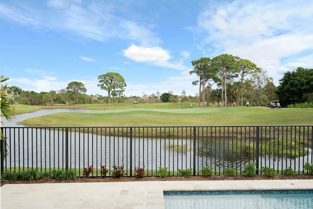 view of swimming pool featuring a water view and a lawn