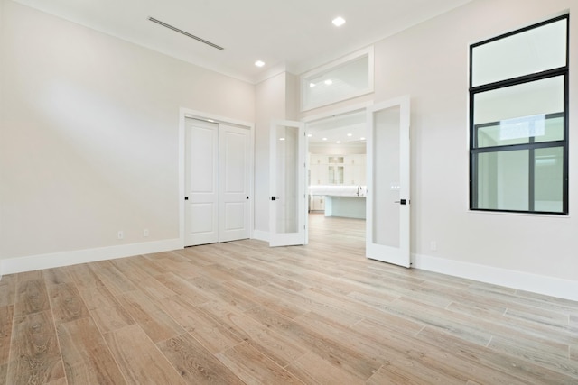 spare room featuring french doors and light wood-type flooring