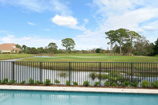 view of pool featuring a yard and a water view