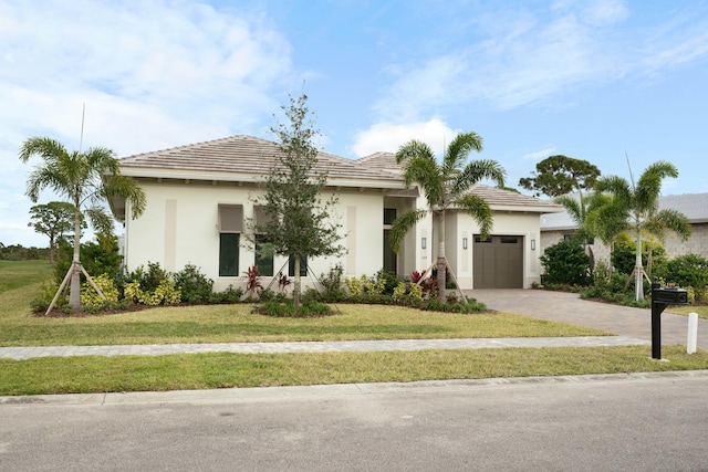 view of front of home featuring a front lawn and a garage