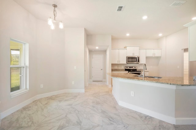 kitchen with white cabinetry, light stone countertops, stainless steel appliances, sink, and light tile floors