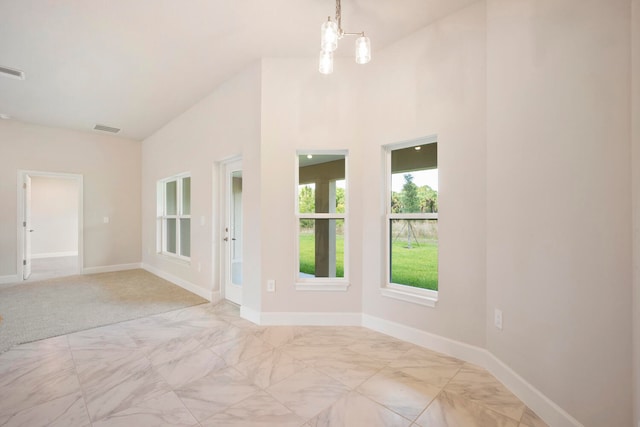 unfurnished room with light carpet and an inviting chandelier