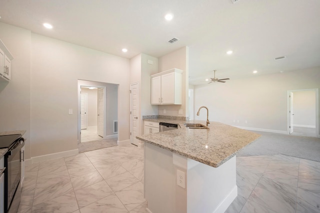 kitchen featuring light carpet, white cabinets, kitchen peninsula, sink, and ceiling fan