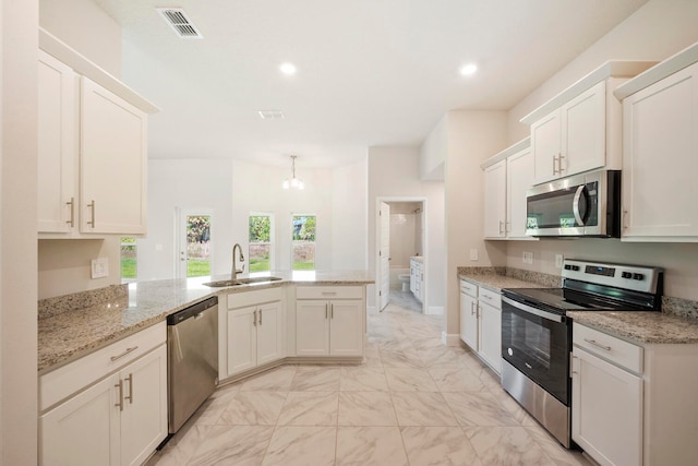 kitchen with kitchen peninsula, light tile floors, sink, white cabinetry, and appliances with stainless steel finishes