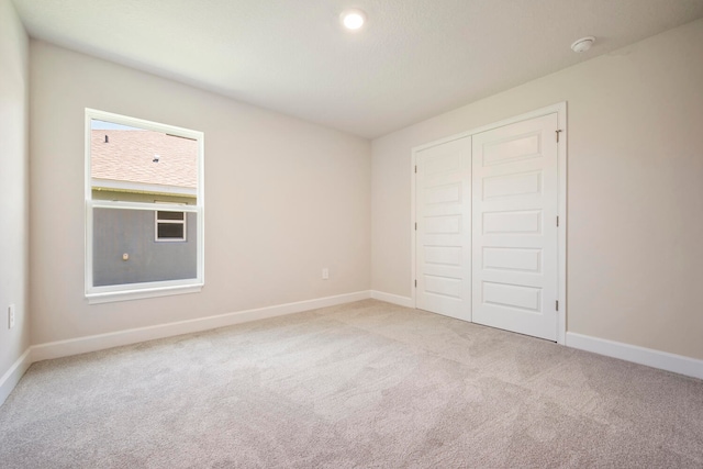 unfurnished bedroom featuring carpet and a closet