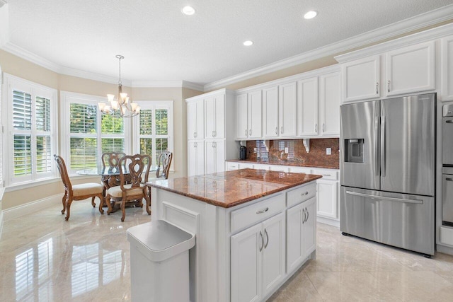 kitchen featuring a notable chandelier, a center island, white cabinetry, and stainless steel appliances