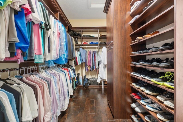 walk in closet with dark wood-type flooring