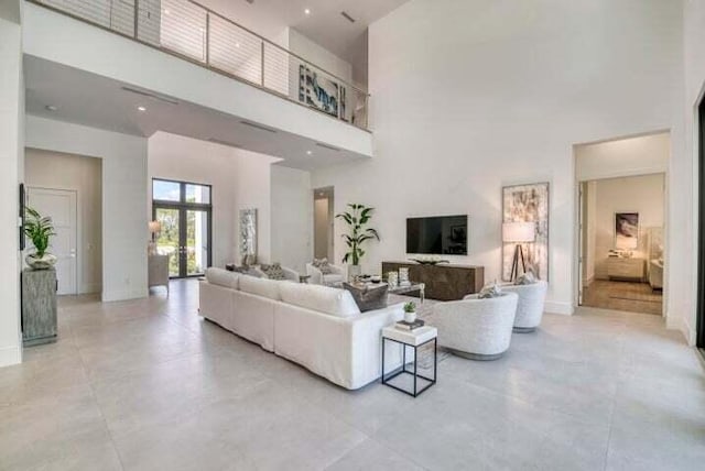 living room featuring a towering ceiling and french doors