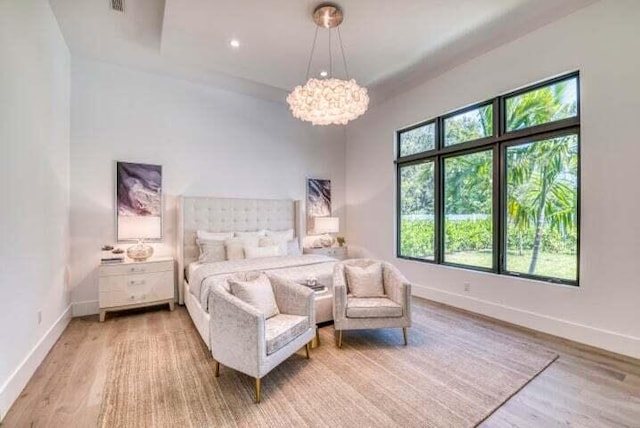 bedroom featuring light hardwood / wood-style flooring and a chandelier