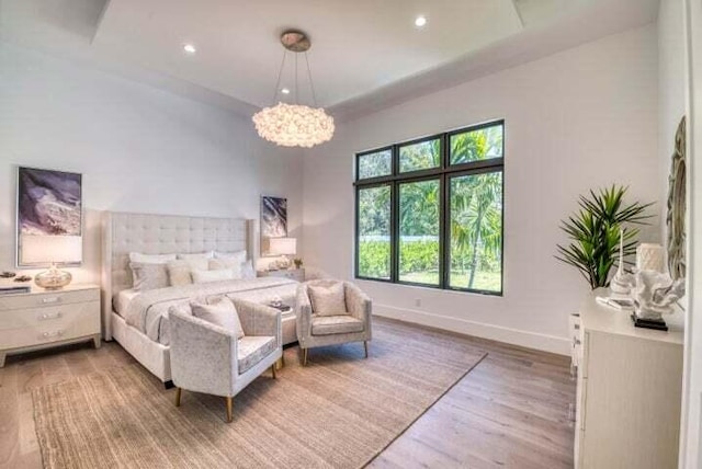 bedroom with a notable chandelier and hardwood / wood-style flooring