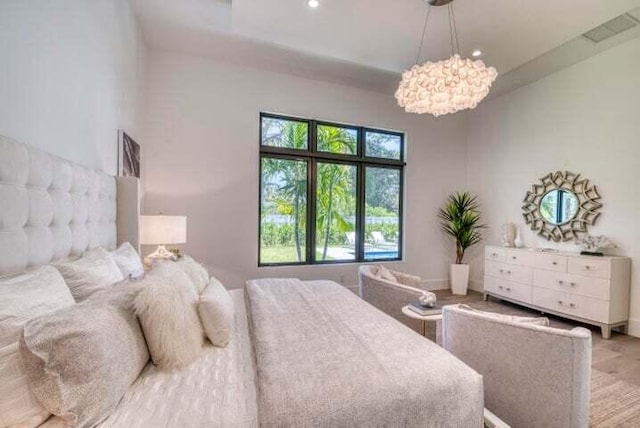 bedroom with a notable chandelier and light hardwood / wood-style floors