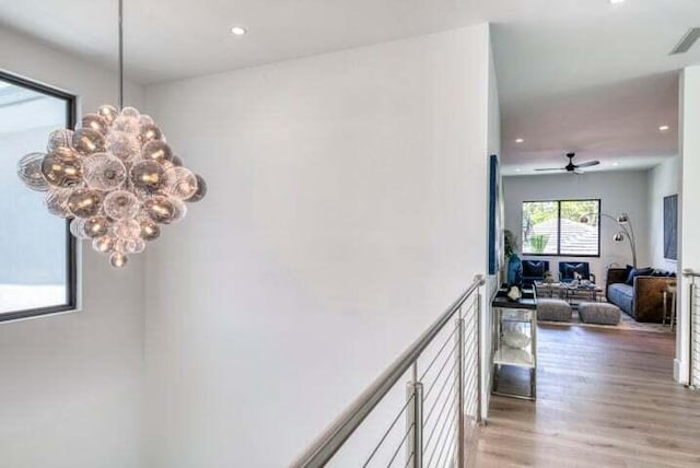 corridor featuring an inviting chandelier and hardwood / wood-style floors