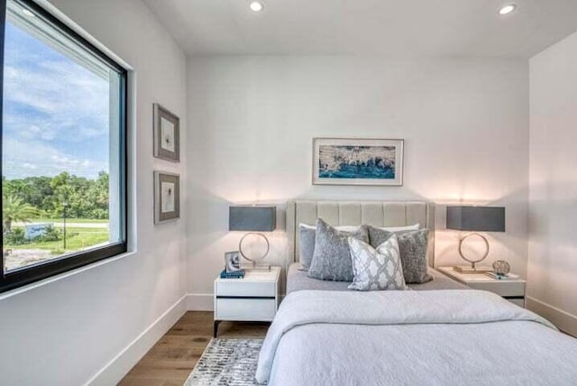 bedroom with wood-type flooring and multiple windows