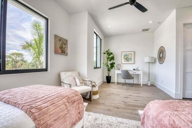 bedroom featuring multiple windows, light hardwood / wood-style floors, and ceiling fan