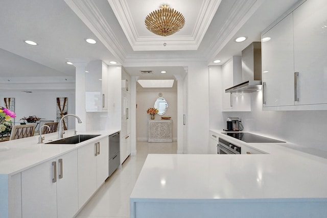 kitchen featuring kitchen peninsula, white cabinets, sink, wall chimney exhaust hood, and stainless steel appliances