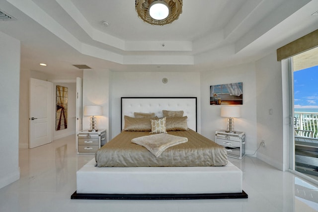 bedroom featuring access to outside, a tray ceiling, and light tile patterned floors