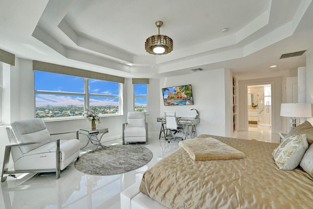 bedroom featuring ensuite bathroom and a tray ceiling