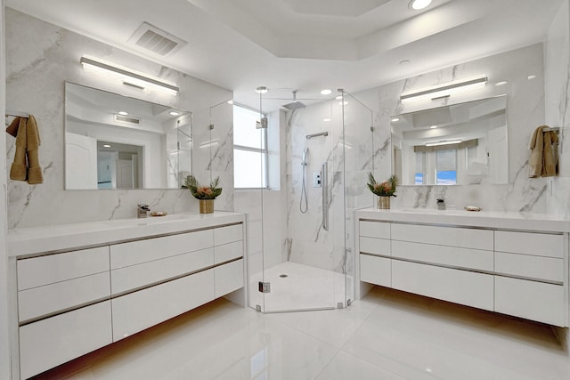 bathroom featuring vanity, a shower with shower door, and a raised ceiling