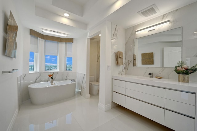 bathroom with vanity, toilet, a tub, and tile patterned flooring