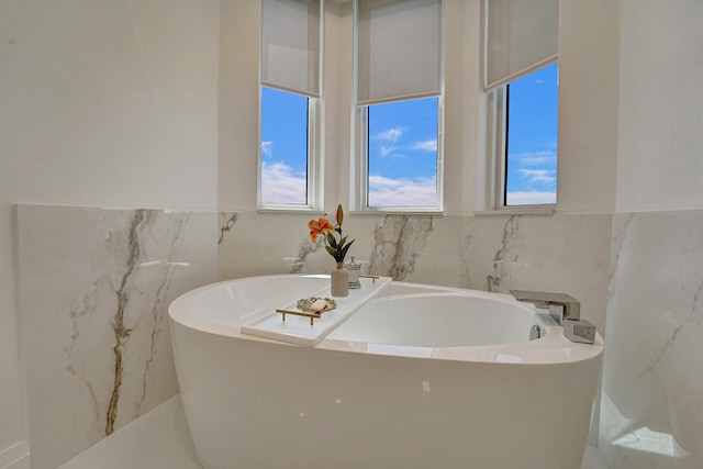 bathroom featuring tile walls and a tub