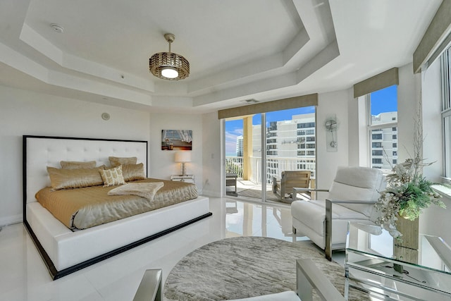 tiled bedroom featuring a tray ceiling and access to exterior