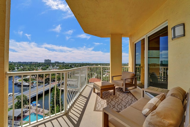 balcony featuring a water view and an outdoor living space