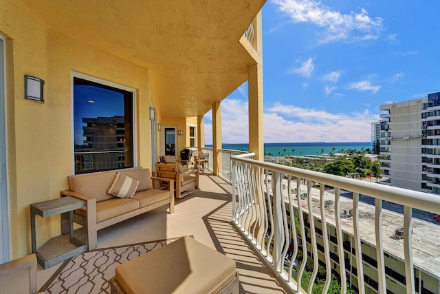 balcony with an outdoor living space and a water view